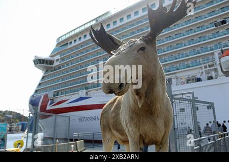 Un alce imbottito sul molo di Kristiansand, Norvegia, con la nave da crociera P&o Britannia nel porto sullo sfondo. Foto Stock