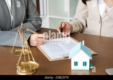 Consulenza legale professionale con avvocati che esaminano documenti contrattuali e scale di giustizia sul desk Foto Stock