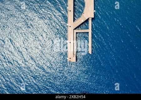Vista aerea del molo di legno che si estende nelle scintillanti acque blu dell'oceano. Limassol, Cipro Foto Stock