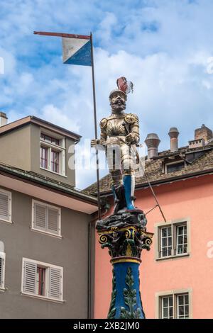 Zurigo, Svizzera - 5 giugno 2024: Cavaliere medievale in armatura completa che regge la bandiera di Zurigo, città vecchia Foto Stock