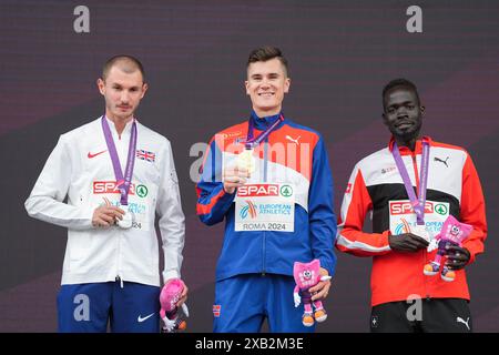 Roma, Italia 20240609. Il vincitore d'oro Jakob Ingebrigtsen alla cerimonia della medaglia per 5000 m, affiancato da George Mills (a sinistra) dalla Gran Bretagna che ha preso l'argento e Dominic Lokinyomo Lobalu dalla Svizzera che ha preso il bronzo durante i Campionati europei di atletica leggera 2024 allo Stadio Olimpico di Roma. Foto: Lise Åserud / NTB Foto Stock