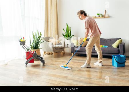 Uomo in azione, lavare il pavimento del soggiorno con uno straccio. Foto Stock