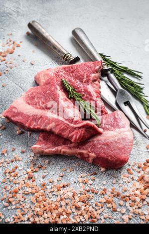 Filetto di manzo al silveside tagliato, carne cruda su macellaio con erbe aromatiche. Sfondo bianco. Vista dall'alto. Foto Stock