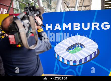 Amburgo, Germania. 10 giugno 2024. Calcio: Campionato europeo, "Stadium Open Media Days". Un cameraman filma striscioni pubblicitari per il Campionato europeo di calcio al Volksparkstadion di Amburgo. I rappresentanti della stampa hanno potuto visitare lo stadio durante un Open Media Day. Crediti: Jens Büttner/dpa/Alamy Live News Foto Stock