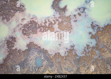 Vista dall'alto verso il basso con drone che cattura le vivaci sfumature di un paesaggio geotermico sulla costa meridionale dell'Islanda, mostrando contrasti e texture sorprendenti. Foto Stock