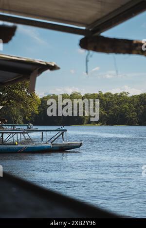 Serena scena di barche da tour attraccate su un tranquillo fiume costaricano, circondate da lussureggianti foreste tropicali, che riflettono un senso di calma avventura Foto Stock