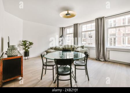 Soggiorno moderno e accogliente con grandi finestre e decorazioni in piante Foto Stock