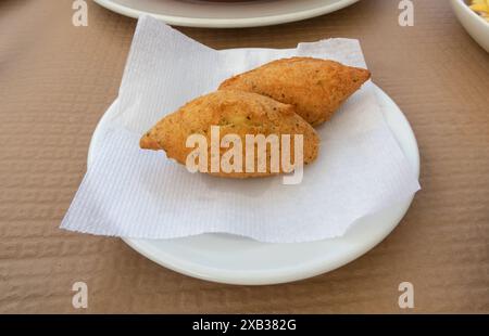 Bolinhos de bacalhau il piatto. Pasteis de bacalhau tradizionale spuntino portoghese a base di patate, merluzzo, uova, prezzemolo e cipolla. Foto Stock