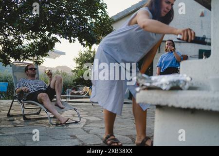 Amici di sesso maschile e femminile che si divertono a fare festa nel cortile posteriore Foto Stock