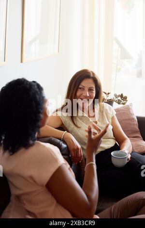 Amici femminili che parlano tra di loro e passano il tempo libero a casa Foto Stock