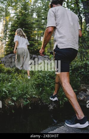 Giovani uomini e donne che camminano attraverso la foresta Foto Stock