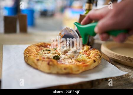 Pizza Margherita fatta in casa tagliata con taglierina allo Street Food Market Foto Stock