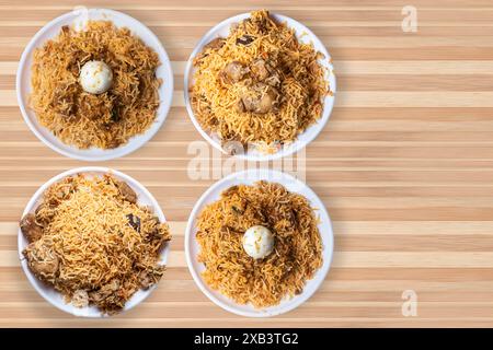 Set di popolari piatti biryani su piatto bianco su sfondo di tavolo in legno. Biryani di pollo, biryani di montone, biryani d'uovo. Foto Stock