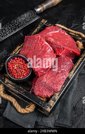 Venison crudo crudo crudo Carne cara, carne di selvaggina. Sfondo nero. Vista dall'alto. Foto Stock