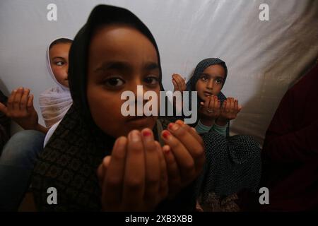 I bambini palestinesi sfollati si riuniscono intorno a un cubo improvvisato che rappresenta la Santa Kaaba i bambini palestinesi sfollati si riuniscono intorno a un cubo improvvisato che rappresenta la Santa Kaaba, in tenda all'interno di un campo per accogliere gli sfollati nell'ospedale dei Martiri di al-Aqsa, il 10 giugno 2024, come parte della formazione dei bambini come eseguire il pellegrinaggio Hajj che è uno dei cinque pilastri dell'Islam. Foto di Omar Ashtawy apaimages Dair EL-Balah Striscia di Gaza territorio palestinese 100624 Dair El-Balah OSH 2 0032 Copyright: XapaimagesxOmarxAshtawyxxapaimagesx Foto Stock