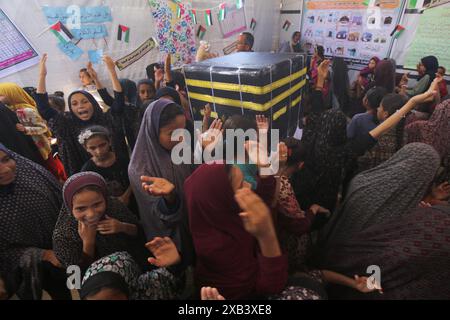 I bambini palestinesi sfollati si riuniscono intorno a un cubo improvvisato che rappresenta la Santa Kaaba i bambini palestinesi sfollati si riuniscono intorno a un cubo improvvisato che rappresenta la Santa Kaaba, in tenda all'interno di un campo per accogliere gli sfollati nell'ospedale dei Martiri di al-Aqsa, il 10 giugno 2024, come parte della formazione dei bambini come eseguire il pellegrinaggio Hajj che è uno dei cinque pilastri dell'Islam. Foto di Omar Ashtawy apaimages Dair EL-Balah Striscia di Gaza territorio palestinese 100624 Dair El-Balah OSH 2 0028 Copyright: XapaimagesxOmarxAshtawyxxapaimagesx Foto Stock