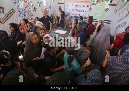 I bambini palestinesi sfollati si riuniscono intorno a un cubo improvvisato che rappresenta la Santa Kaaba i bambini palestinesi sfollati si riuniscono intorno a un cubo improvvisato che rappresenta la Santa Kaaba, in tenda all'interno di un campo per accogliere gli sfollati nell'ospedale dei Martiri di al-Aqsa, il 10 giugno 2024, come parte della formazione dei bambini come eseguire il pellegrinaggio Hajj che è uno dei cinque pilastri dell'Islam. Foto di Omar Ashtawy apaimages Dair EL-Balah Striscia di Gaza territorio palestinese 100624 Dair El-Balah OSH 2 0027 Copyright: XapaimagesxOmarxAshtawyxxapaimagesx Foto Stock