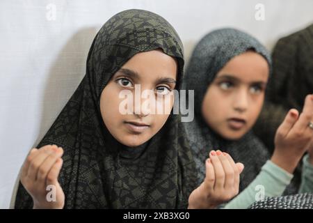 I bambini palestinesi sfollati si riuniscono intorno a un cubo improvvisato che rappresenta la Santa Kaaba i bambini palestinesi sfollati si riuniscono intorno a un cubo improvvisato che rappresenta la Santa Kaaba, in tenda all'interno di un campo per accogliere gli sfollati nell'ospedale dei Martiri di al-Aqsa, il 10 giugno 2024, come parte della formazione dei bambini come eseguire il pellegrinaggio Hajj che è uno dei cinque pilastri dell'Islam. Foto di Omar Ashtawy apaimages Dair EL-Balah Striscia di Gaza territorio palestinese 100624 Dair El-Balah OSH 2 009 Copyright: XapaimagesxOmarxAshtawyxxapaimagesx Foto Stock