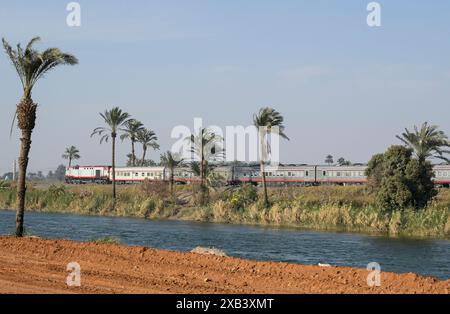 EGITTO, Assiut, lungo 350 km il canale Ibrahimiyya trasporta l'acqua del Nilo per l'irrigazione, treno passeggeri sulla linea ferroviaria Cairo-Asyut / ÄGYPTEN, Asyut, Ibrahimiyya-Kanal, der Kanal ist 350 km lang und bringt Wasser vom Nil zur landwirtschaftlichen Bewässerung, Bahnlinie Kairo-Assiut Foto Stock