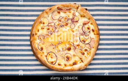 Vista dall'alto della pizza carbonara con uovo al centro. Menu Pizza. Cucina italiana Foto Stock