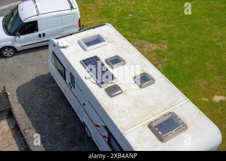 Conwy Wales Regno Unito 06-01-2024. Vista aerea di un camper con pannelli solari parcheggiati accanto a un furgone bianco su un prato verde. Foto Stock