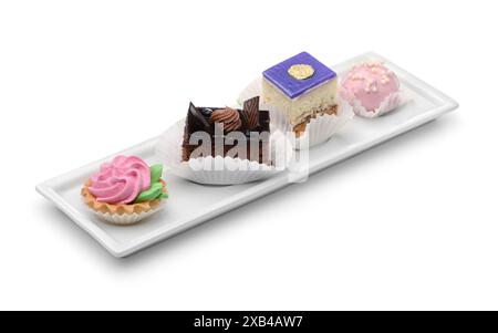 Set di diverse mini torte su piastra rettangolare isolata su bianco Foto Stock