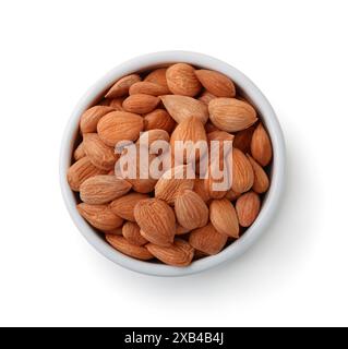 Vista dall'alto dei chicchi di albicocche sbucciati in un recipiente di ceramica isolato su bianco Foto Stock