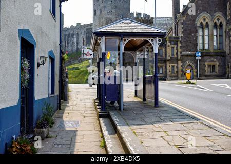 Conwy Wales Regno Unito 06-01-2024. Fermata dell'autobus nella città storica vicino all'antico castello, che unisce il transito moderno all'architettura medievale Foto Stock