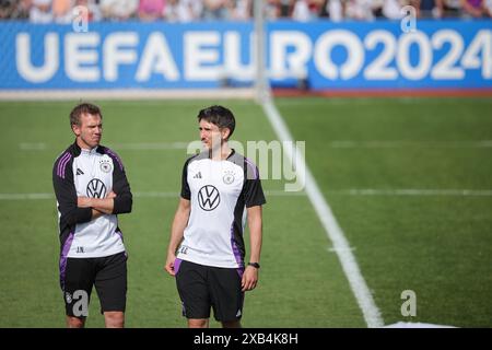 Herzogenaurach, Germania. 10 giugno 2024. Calcio, preparazione per il Campionato europeo, allenamento, squadra nazionale tedesca. L'allenatore tedesco Julian Nagelsmann (l) e l'assistente allenatore Benjamin Glück si trovano uno accanto all'altro in campo durante gli allenamenti pubblici all'Adi-Dassler-Stadion. Credito: Christian Charisius/dpa/Alamy Live News Foto Stock