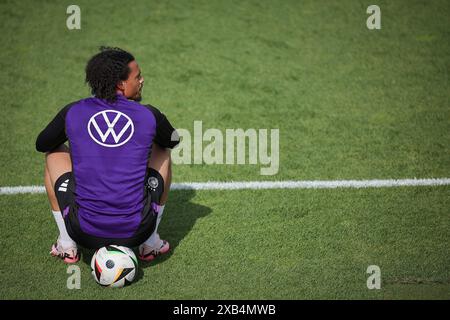 Herzogenaurach, Germania. 10 giugno 2024. Calcio, preparazione per il Campionato europeo, allenamento, squadra nazionale tedesca. Il tedesco Leroy sane si siede su un pallone durante gli allenamenti pubblici allo stadio Adi Dassler. Credito: Christian Charisius/dpa/Alamy Live News Foto Stock