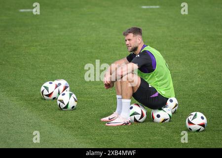 Herzogenaurach, Germania. 10 giugno 2024. Calcio, preparazione per il Campionato europeo, allenamento, squadra nazionale tedesca. Il tedesco Niclas Füllkrug si siede su un pallone durante gli allenamenti pubblici allo stadio Adi Dassler. Credito: Christian Charisius/dpa/Alamy Live News Foto Stock