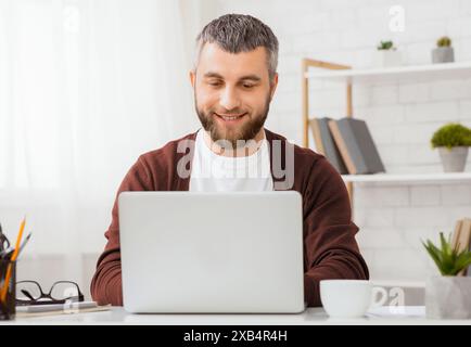 Uomo imprenditore seduto davanti al computer portatile Foto Stock