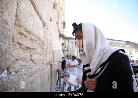 L'ebreo ultra-ortodosso che indossa un Talith e un Tefillin prega e medita con altri ebrei al muro Occidentale Foto Stock