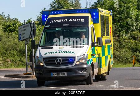 Stony Stratford, Regno Unito - 2 giugno 2024: Ambulanza di emergenza in risposta a un incidente, luci blu lampeggianti su una strada di campagna britannica Foto Stock