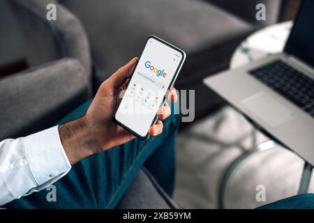 Uomo d'affari che utilizza il sito Web di ricerca di Google su un telefono cellulare per effettuare una ricerca su Internet. Rosario, Argentina - 6 giugno 2024. Foto Stock