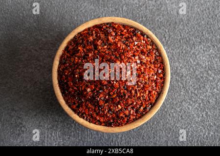 Peperoncino rosso. Peperoncini rossi in un recipiente di legno su sfondo grigio Foto Stock