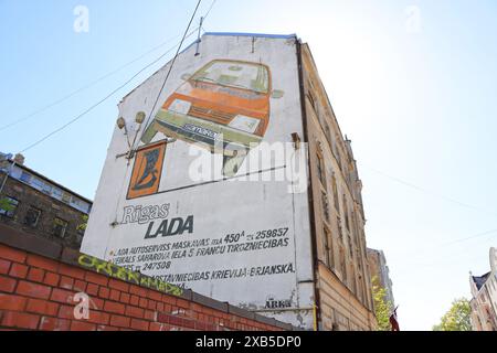 Pubblicità sovietica pre-capitalista per un'auto Lada Samura con una versione spiritosa, su Krasotaju St nel quartiere Grizinkalns, nei sobborghi di riga, in Lettonia Foto Stock