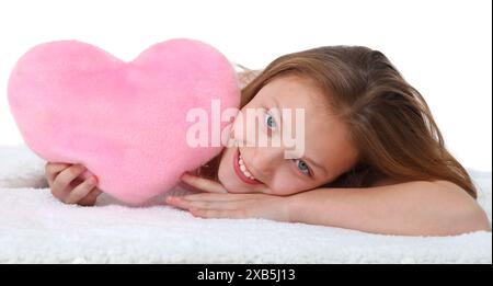 bambina con cuscino a cuore rosa su sfondo bianco Foto Stock