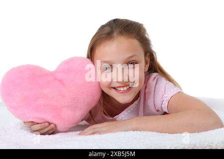 bambina con cuscino a cuore rosa su sfondo bianco Foto Stock