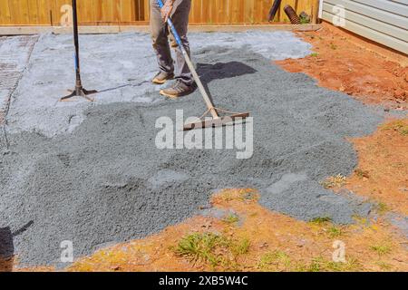 Durante i lavori di costruzione, il terreno viene livellato con pietre di ghiaia finissima per versare prima il calcestruzzo nelle fondamenta della casa Foto Stock