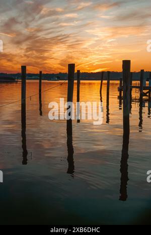 Il tramonto sulla costa del Connecticut proietta sfumature ispiranti tra le nuvole in un cielo blu che svanisce e si riflette sulle calme acque del canale. Foto Stock