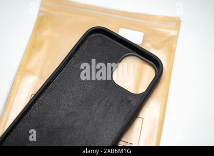 Custodia protettiva in silicone per iPhone 15 su una cover marrone. Sfondo bianco. Foto Stock