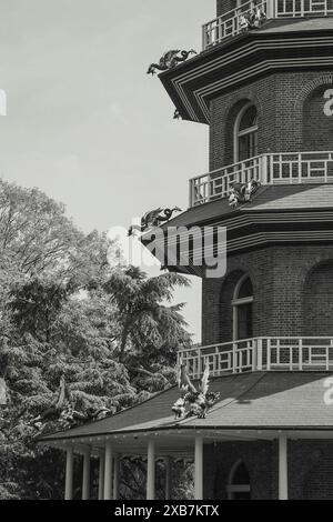Un'immagine monocromatica di un edificio in mattoni con statue di draghi su di esso Foto Stock