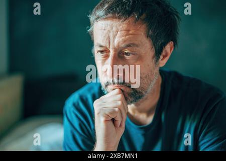 Uomo disgustato, preoccupato e profondamente assorbito dai pensieri, concentrazione selettiva Foto Stock