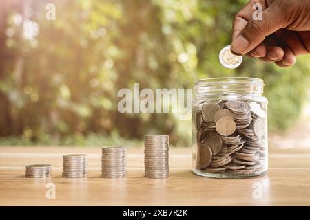 Monete in un vaso di vetro trasparente per risparmiare denaro Foto Stock