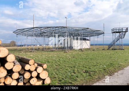 Numerosi registri impilati nel campo vicino all'edificio Foto Stock