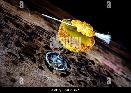 Un cocktail tropicale guarnito con ananas in un bicchiere Foto Stock