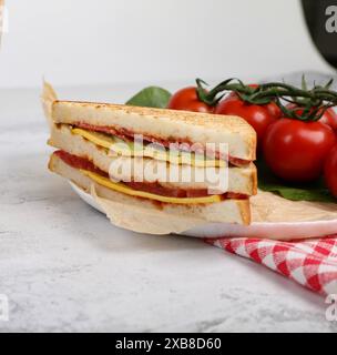 Un mezza panino con formaggio e pomodoro, accanto ai pomodori freschi Foto Stock