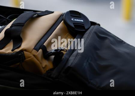 Un primo piano di accessori per fotocamera sulla borsa Wandrd Sling con copriobiettivo Canon Foto Stock