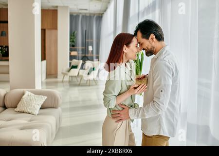 Un giovane uomo e una donna, una donna rossa e un uomo barbuto, stanno insieme in un soggiorno di un appartamento moderno, trascorrendo del tempo insieme. Foto Stock